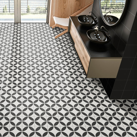 Black and white geometric tiles cover a bathroom floor with a circular pattern. black sinks and mirrors sit on a wooden vanity.