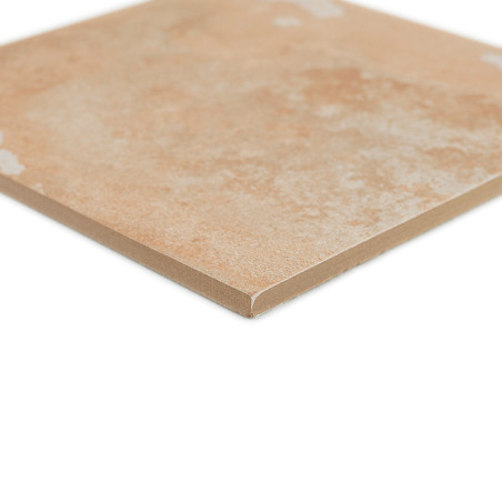 Un carreau de céramique carré beige à la surface légèrement texturée repose sur un fond blanc, mettant en valeur ses bords lisse