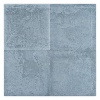 Un azulejo cuadrado con una textura rugosa y desigual muestra tonos moteados de gris y azul, que se asemejan a la piedra natural