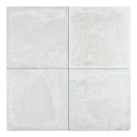 Un conjunto de cuatro azulejos cerámicos texturizadas de color gris claro dispuestas en un cuadrado, que exhiben un patrón sutil