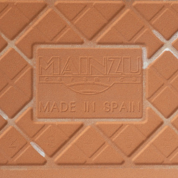 Um ladrilho cerâmico de terracota apresenta padrões de diamante em relevo e texto em relevo que diz “MAINZU ceramica” e “MADE IN