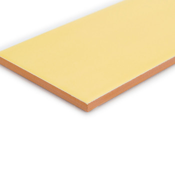 Um ladrilho retangular amarelo claro repousa sobre uma superfície branca, exibindo uma camada superior lisa com uma borda marrom