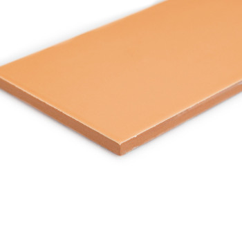 Un azulejo rectangular de color beige yace plano, mostrando una superficie lisa, sin textura y bordes afilados, fotografiado sob