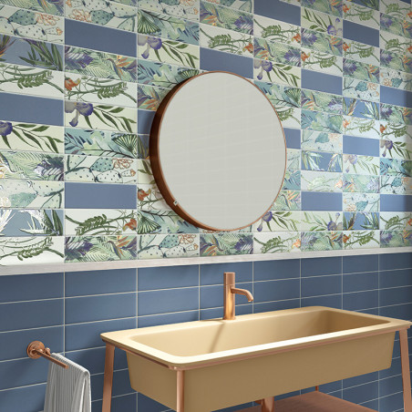 Een moderne badkamer is voorzien van een ronde spiegel en een beige wastafel met een roségouden kraan, afgezet tegen blauwe tege