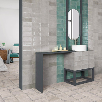 La configuración de un baño moderno presenta azulejos grises brillantes con una franja vertical de azulejos verde azulado. Una e
