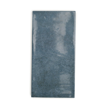 Azulejo de cerámica rectangular, que muestra una superficie brillante y opaca de color gris azulado. aparece sobre un fondo blan