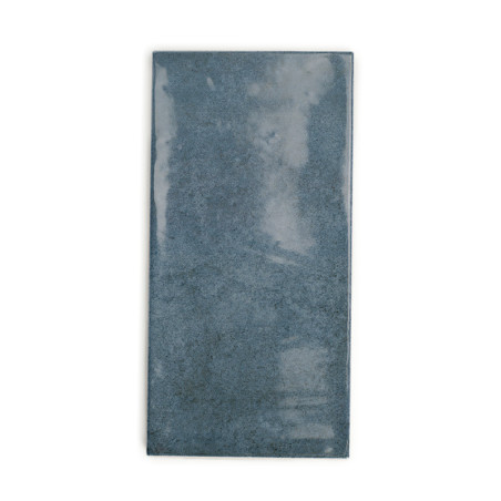 Azulejo de cerámica rectangular, que muestra una superficie brillante y opaca de color gris azulado. aparece sobre un fondo blan