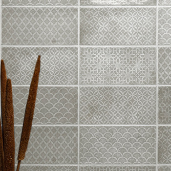 Seize carreaux gris présentent divers motifs géométriques. Les motifs texturés comprennent des diamants, des cercles et des écai