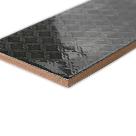 Um ladrilho preto brilhante apresenta um padrão de grade, apoiado em um fundo branco liso, mostrando sua superfície lisa e refle