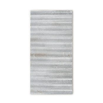 Un azulejo rectangular presenta crestas lineales horizontales, desiguales en diferentes tonos de gris claro, lo que sugiere un e