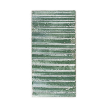 Un azulejo rectangular muestra rayas horizontales verdes y blancas con una textura desgastada, lo que sugiere una sensación rúst