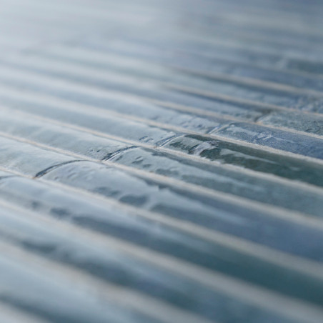 De focus ligt op getextureerde, rechthoekige glastegels, uitgelijnd in parallelle rijen. Licht reflecteert zachtjes op het gladd