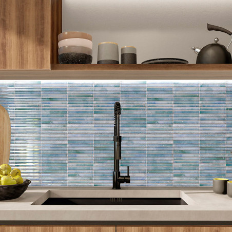 Des carreaux de mosaïque bleue tapissent le dosseret de la cuisine, complétant un robinet noir au-dessus d'un évier. armoires et