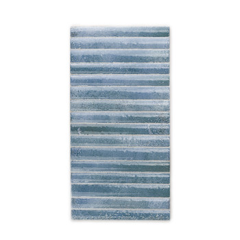 Azulejo rectangular con rayas horizontales en diferentes tonos de azul, creando un efecto texturizado y en capas. El fondo es se
