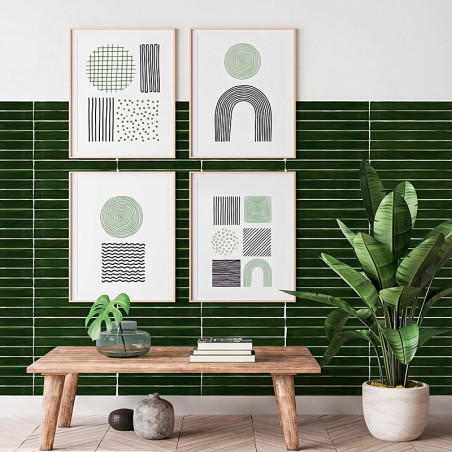L'art abstrait encadré est accroché à un mur avec des carreaux verts horizontaux. Un banc en bois en dessous contient une plante