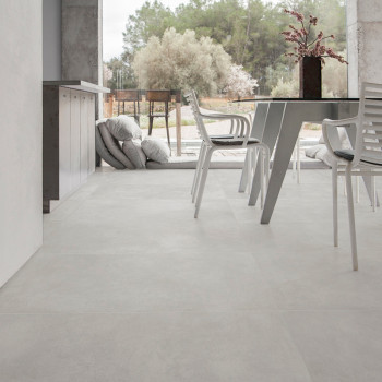 Los azulejos de color gris claro crean una apariencia moderna y perfecta dentro de una habitación espaciosa con sillas y una mes