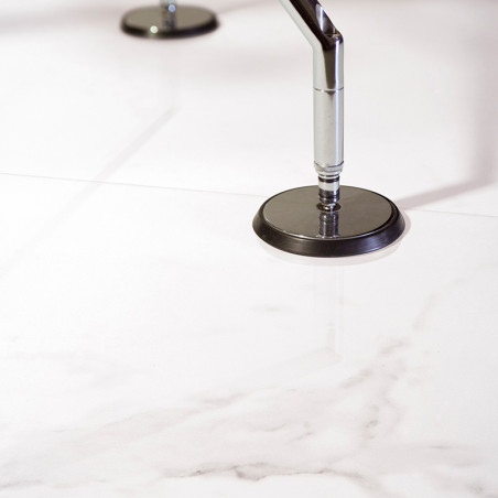 Un carreau de marbre blanc et lisse reflète deux bouchons métalliques le fixant à la surface brillante, lui conférant un design 
