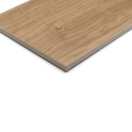 A flat, rectangular ceramic tile mimics natural wood grain with light brown tones. It rests on a plain, white background.
