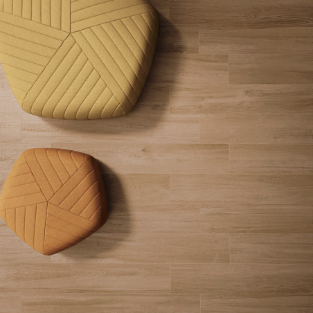 Dos otomanas hexagonales coloridas y texturizadas se sientan tranquilamente sobre un piso de madera clara, creando un ambiente i