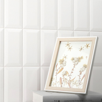 Une image encadrée en bois présente des œuvres d’art floral aux côtés de motifs étoilés, posées sur deux livres empilés contre u
