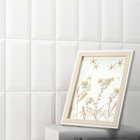 Une image encadrée en bois présente des œuvres d’art floral aux côtés de motifs étoilés, posées sur deux livres empilés contre u