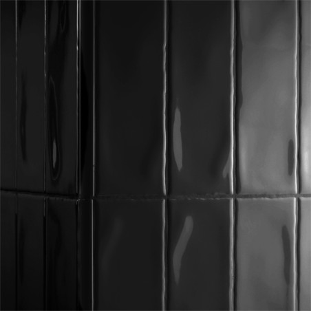 Glänzend schwarze Fliesen reflektieren das Licht vertikal und schaffen eine elegante und moderne Oberfläche in einem schwach bel