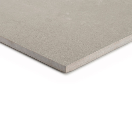 Een beige, vierkante tegel ligt plat met het gladde oppervlak zichtbaar, de randen licht afgeschuind, tegen een witte achtergron