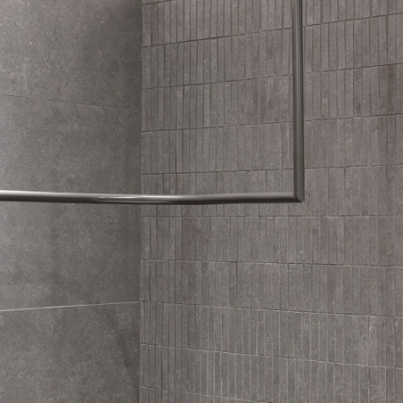 Grijze rechthoekige tegels omlijnen een muur- en vloerhoek en creëren een moderne, minimalistische uitstraling. Een metalen fram