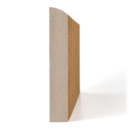 Un rodapie beige rectangular se encuentra en posición vertical, con su superficie lisa mirando hacia adelante, proyectando una sombra sobre un fondo blanco.