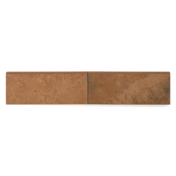 Un rodapie cerámico marrón rectangular con una superficie texturizada descansa sobre un fondo blanco liso, lo que sugiere su uso en construcción o decoración.