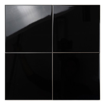 Four glossy black tiles reflect light, arranged in a square grid pattern, set against a plain white background.