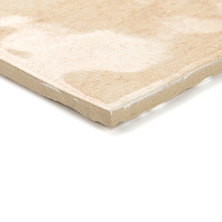 Auf einem weißen Hintergrund liegt eine beige Keramikfliese mit glatter, glänzender Oberfläche. Die Fliese weist dezente Marmorm