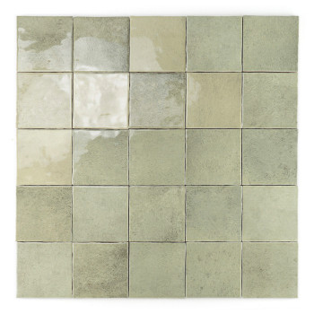 Un azulejo cuadrado verde brillante y apagado se asienta solo sobre un fondo blanco, mostrando una sutil textura de mármol con t