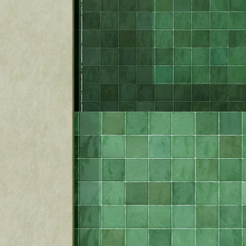 Groene keramische tegels vormen een geometrisch patroon en creëren een glad, reflecterend oppervlak op een verticale muur, begre