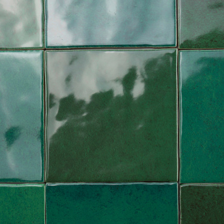 Groene tegels bedekken een oppervlak en reflecteren vage schaduwen en licht, waardoor een glanzend, onregelmatig patroon ontstaa