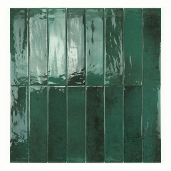 Un azulejo cerámico brillante, rectangular y de color verde intenso refleja la luz, creando un efecto de espejo en un entorno se