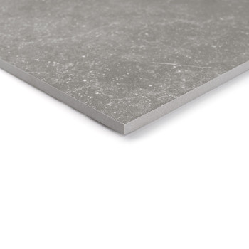 Un azulejo cerámico cuadrada de color gris presenta sutiles motas blancas, colocada sobre una superficie blanca lisa, mostrando 