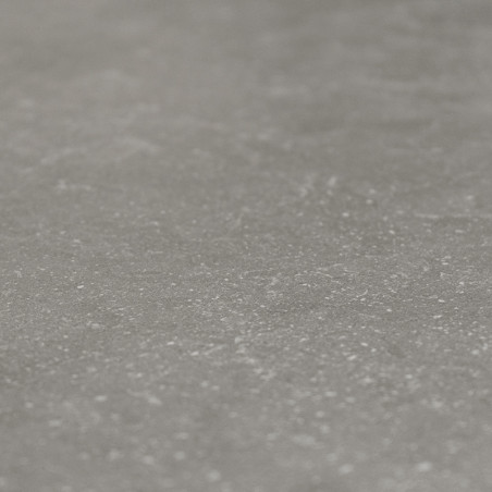 Un azulejo gris liso muestra un patrón sutil y moteado, que imita la textura de la piedra natural en un ambiente interior discre