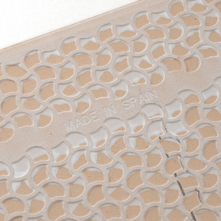 Un azulejo muestra un patrón de hojas tallado y repetitivo con `MADE IN SPAIN` en relieve, mostrando intrincados detalles de dis