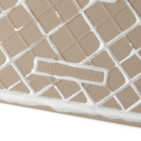 Um ladrilho bege exibe linhas de grade diagonais com lacunas de preenchimento de argamassa branca. O centro diz "MADE IN SPAIN",