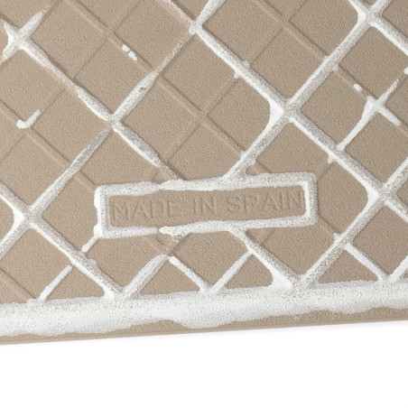 Un carreau beige présente un motif de grille en diamant en relief rempli de coulis blanc. Le texte « MADE IN SPAIN » est gravé a