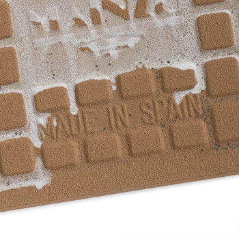Les carreaux de céramique carrés et texturés portent les mots « MADE IN SPAIN » en lettres en retrait, partiellement recouverts 