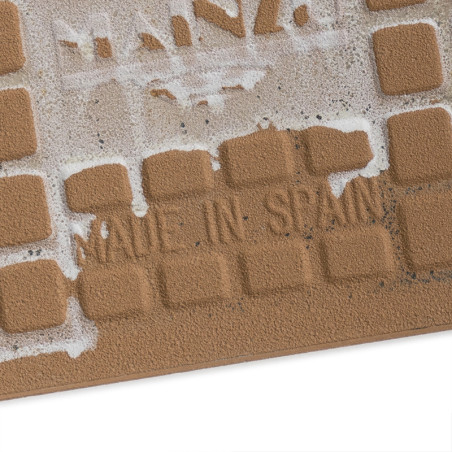 Les carreaux de céramique carrés et texturés portent les mots « MADE IN SPAIN » en lettres en retrait, partiellement recouverts 