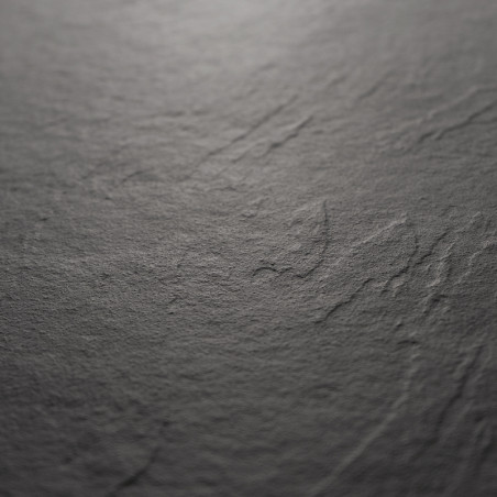 Una losa de piedra oscura y texturizada muestra surcos naturales y sutiles variaciones de tono, evocando una superficie rugosa s