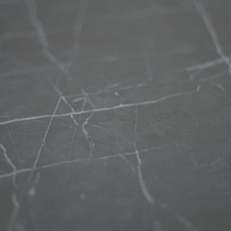 Un azulejo de mármol gris oscuro con finas vetas blancas recorre en diagonal la superficie lisa, sobre un fondo uniforme.