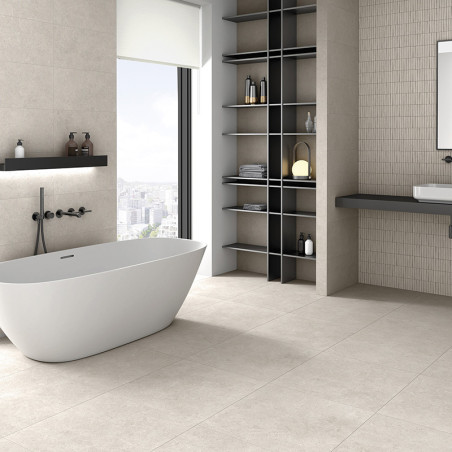 Een moderne badkamer is voorzien van een strak wit bad onder een groot raam. Planken met toiletartikelen naast een zwevende wast