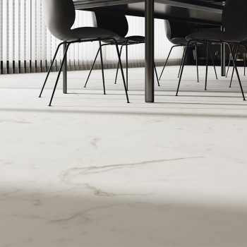 Witte marmeren tegels overspannen de vloer en voegen elegantie toe onder een moderne eettafel met zwarte stoelen. Zonlicht filte