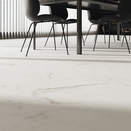 Witte marmeren tegels overspannen de vloer en voegen elegantie toe onder een moderne eettafel met zwarte stoelen. Zonlicht filte