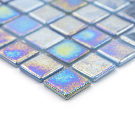Schillernde Glasfliesen reflektieren bunte Lichtmuster, die in einem geometrischen Raster auf einer weißen Oberfläche angeordnet