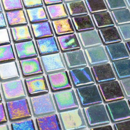 Square tiles reflect iridescent colors, creating a shimmering pattern on a flat surface in a grid arrangement.